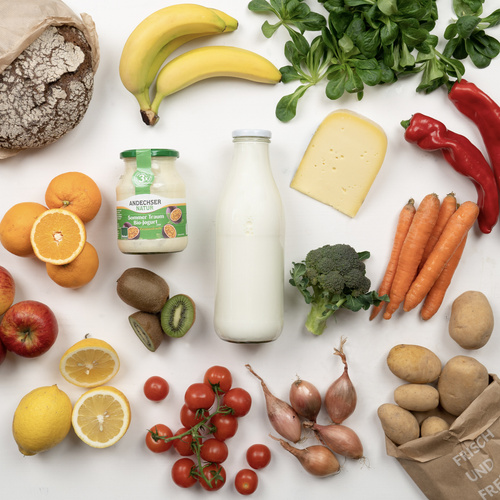 KI generiert: Verschiedene Lebensmittel, darunter Obst, Gemüse, Brot, Käse, Joghurt und Milch. Text: „FRISCH UND“.