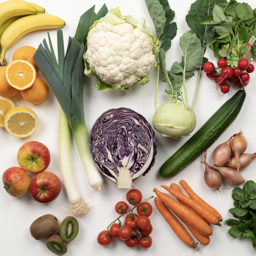 KI generiert: Verschiedene Obst- und Gemüsesorten auf weißem Hintergrund arrangiert.