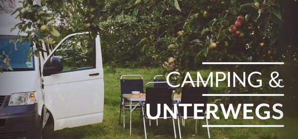 KI generiert: Ein Van und Campingstühle stehen unter einem Apfelbaum. Text: "CAMPING & UNTERWEGS".