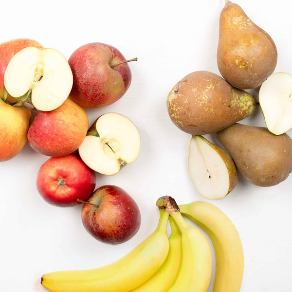 KI generiert: Verschiedene Obst- und Gemüsesorten auf weißem Hintergrund arrangiert.