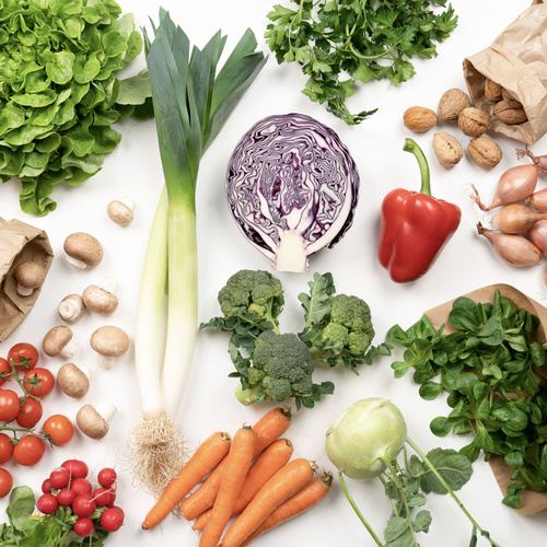 KI generiert: Verschiedene frische Gemüse wie Lauch, Paprika, Karotten, Pilze und Rotkohl auf weißem Hintergrund.